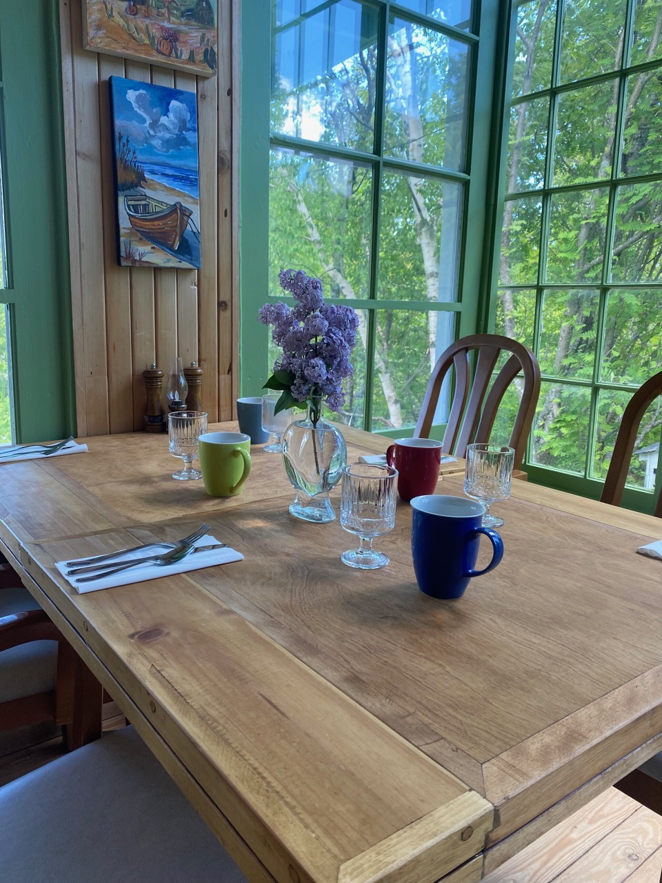A table awaits at Auberge Romance with paintings surrounding it by Louise Bellay and the hands-on experience of cooking raclette style at breakfast and on a hot stone at dinner.